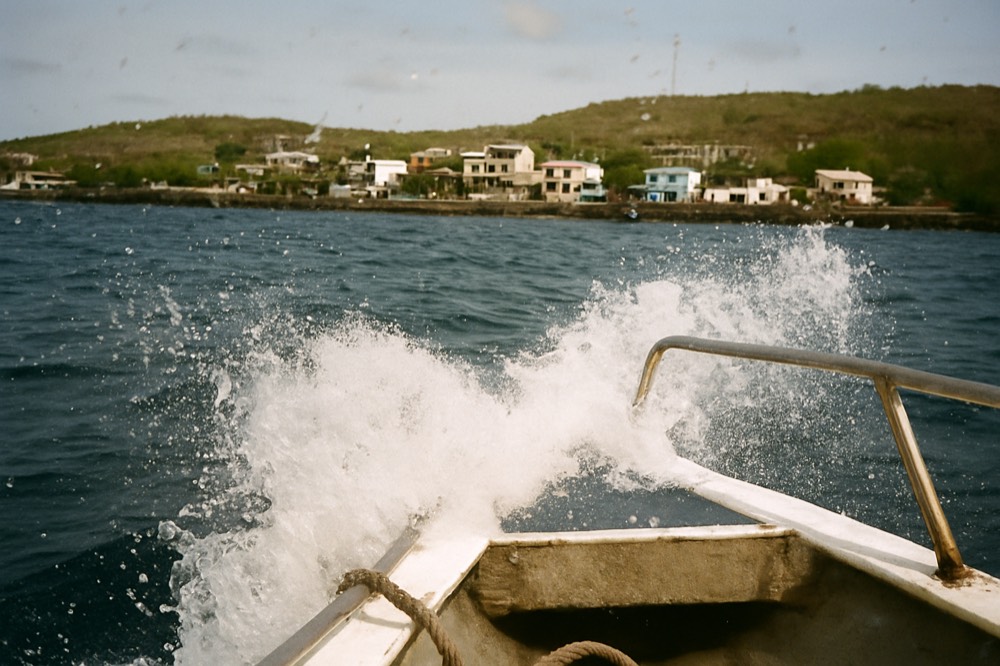 Open blue ocean from the bow of a moving speedboat with spray at the rail