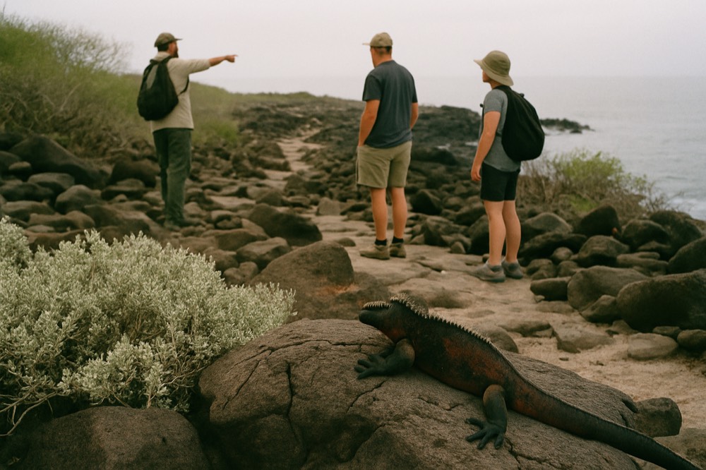 A naturalist guide speaking with a small group on a rocky shoreline trail